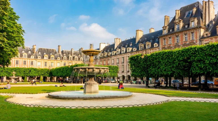 Place des Vosges in the morning with people on the lawn