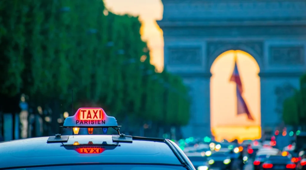 Taxi in Paris at night with the Arc de Triomphe in the background