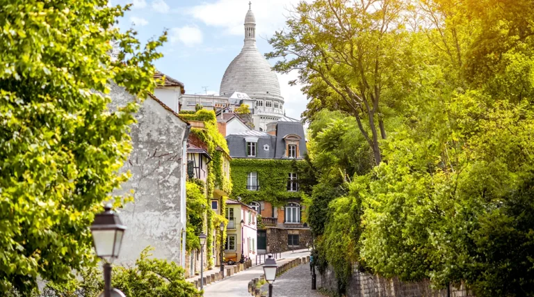 Cityscape view on the beautiful street with the Sacré-Coeur Cathedral on the hill of Monmartre in Paris
