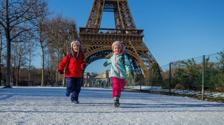 Children play on Champ de Mars after a snowfall