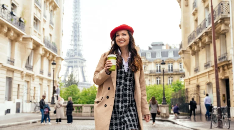 Woman walking through Paris with a cup of coffee