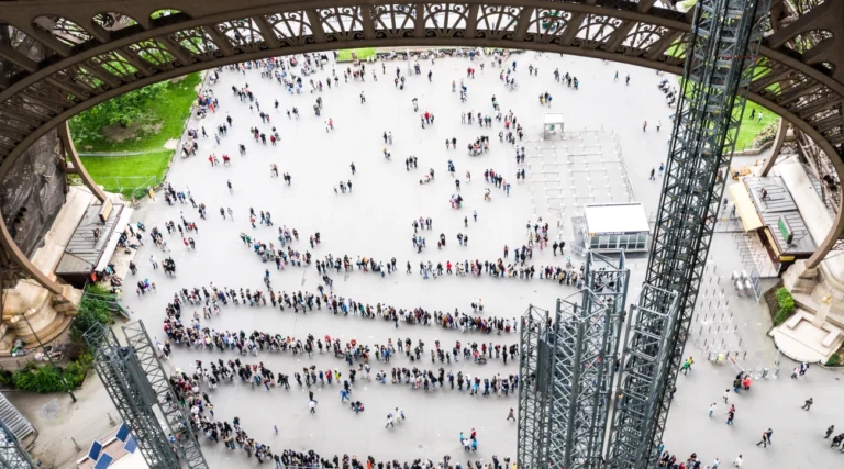 People queuing at the foot of the Eiffel Tower